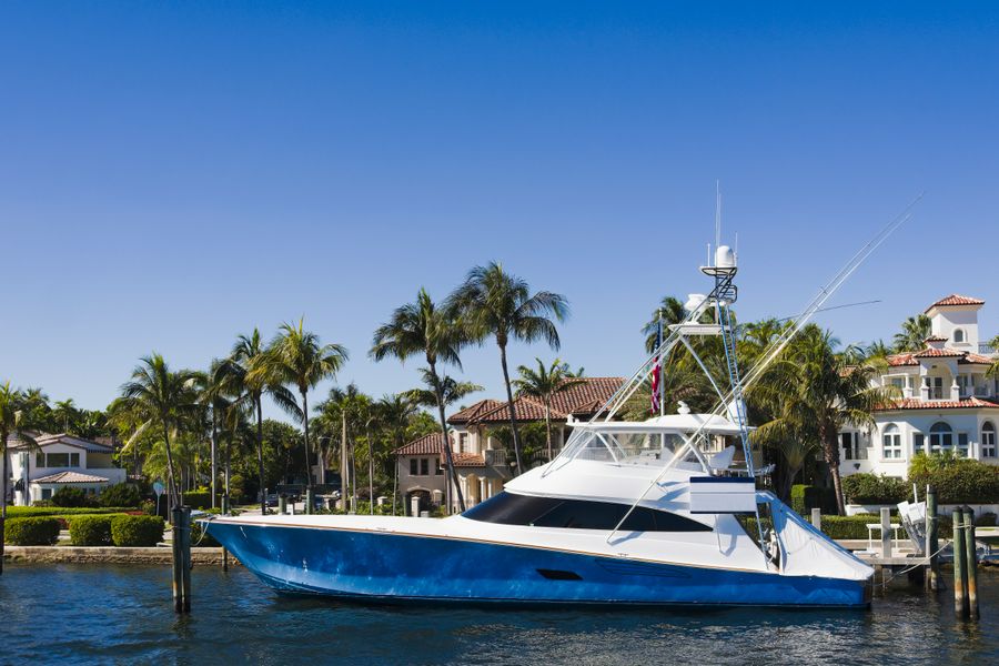 Sportfishing yacht docked by palm trees and waterfront homes in Fort Lauderdale