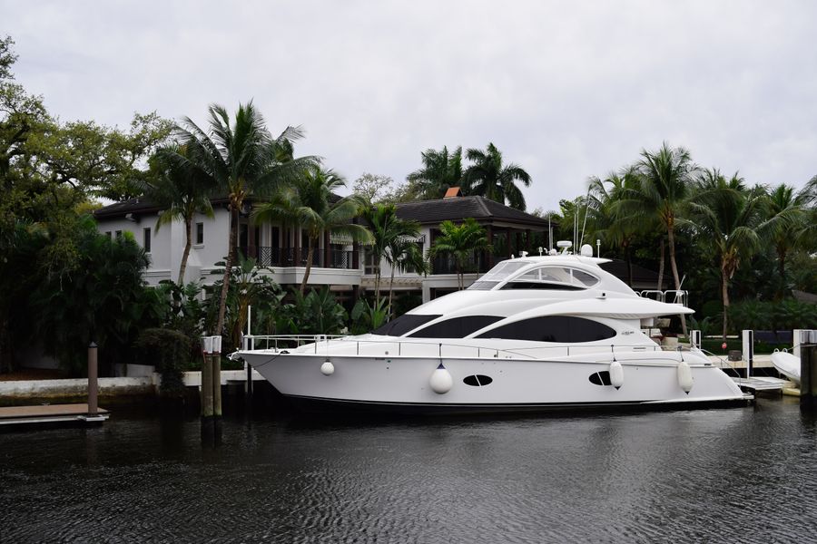 White motor yacht docked at a waterfront home in Fort Lauderdale